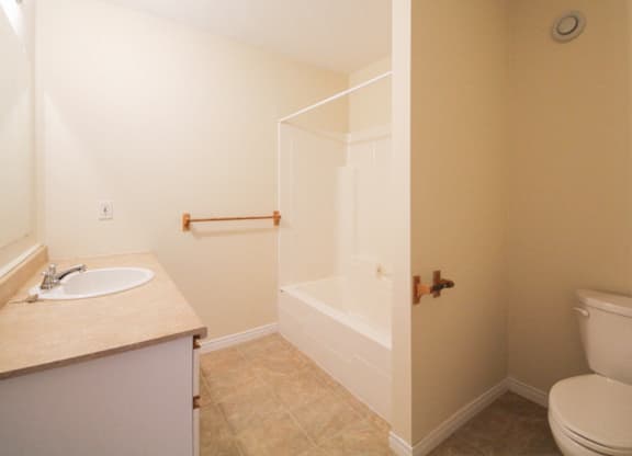 A bathroom with a toilet, sink, and bathtub.