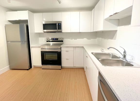 A kitchen with white cabinets and stainless steel appliances.