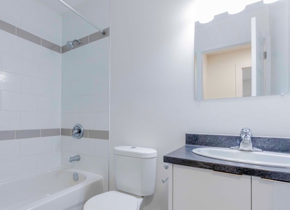 A white toilet sits next to a bathtub in a bathroom.