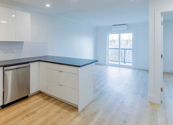 A kitchen with white cabinets and a black countertop.