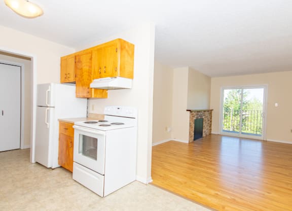 A kitchen with white appliances and wooden cabinets.