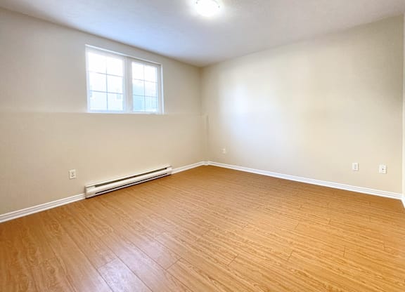A room with a window and a radiator on the wall.