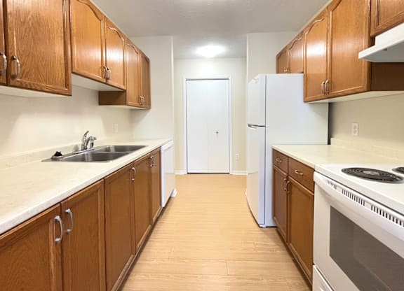 A kitchen with wooden cabinets and white appliances.