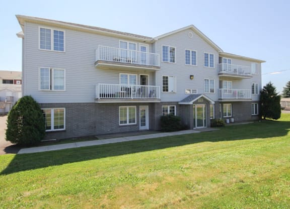 A large two-story apartment building with a balcony on the second floor.