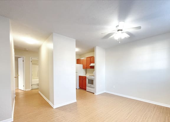 A room with a ceiling fan and wooden flooring.