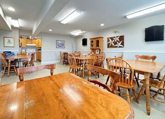 A room with wooden chairs and tables.