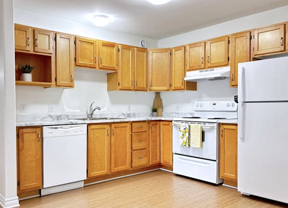 A kitchen with wooden cabinets and white appliances.