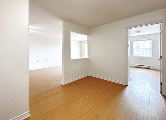 Empty room with wooden floors and white walls.