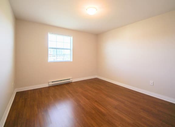 A room with a window and a radiator on the floor.