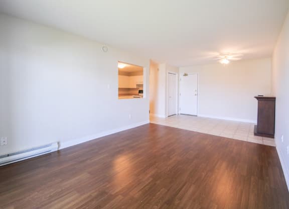 Empty room with wooden floors and white walls.