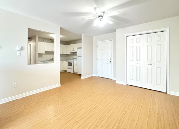 A room with a ceiling fan and wooden flooring.
