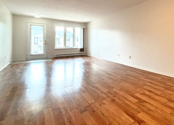 A room with wooden flooring and two doors.