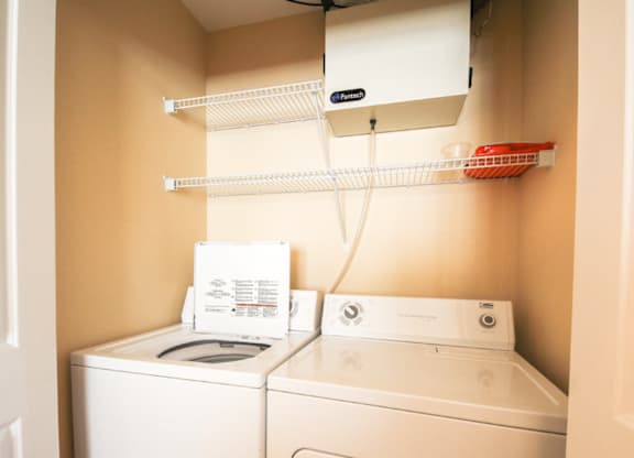 A white washing machine and dryer in a small laundry room.
