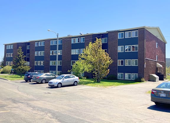A parking lot with cars and a building in the background.