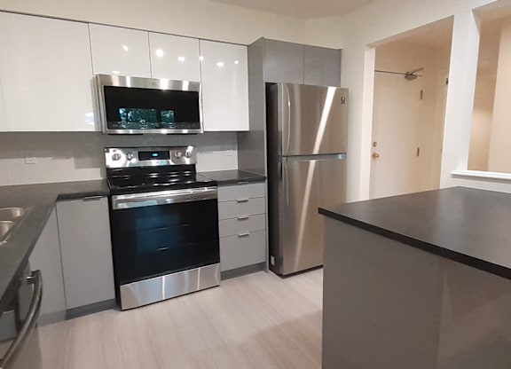 A modern kitchen with stainless steel appliances and white cabinets.