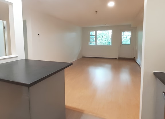 A room with a black countertop and wooden flooring.