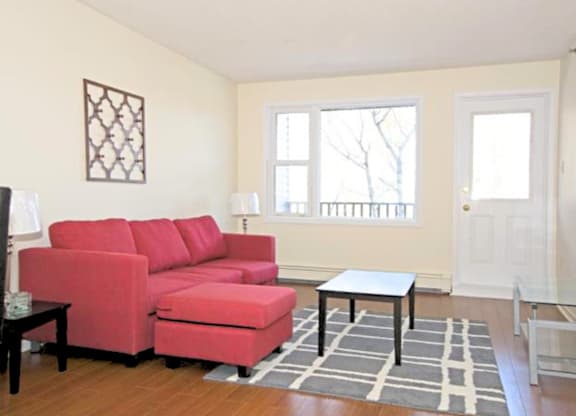 A red couch in a living room with a small table in front of it.