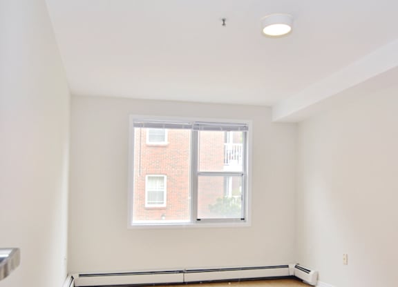 A room with a window and a radiator on the wall.