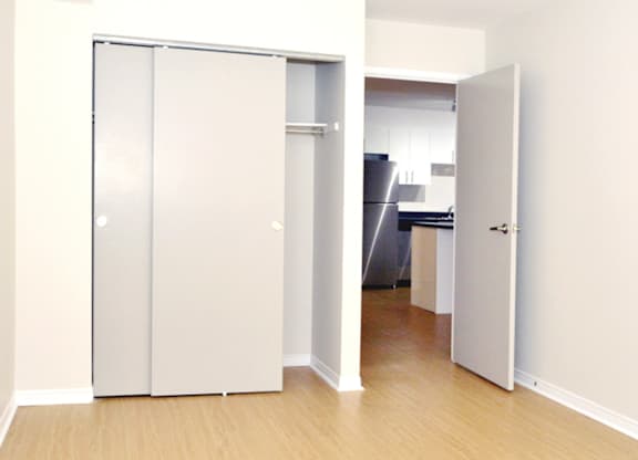 A white door is open to a kitchen.