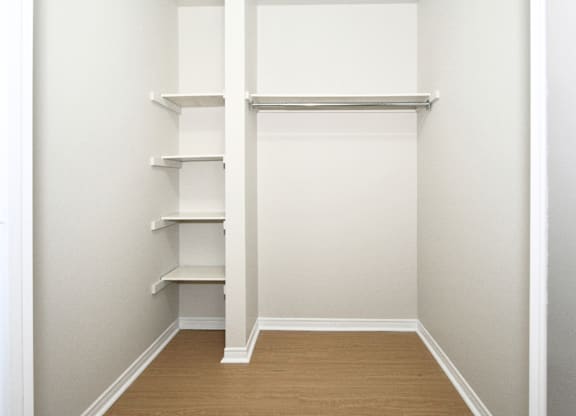 A white shelving unit in a room with white walls.