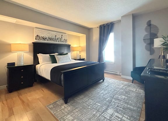 A bedroom with a large bed and a painting above it.