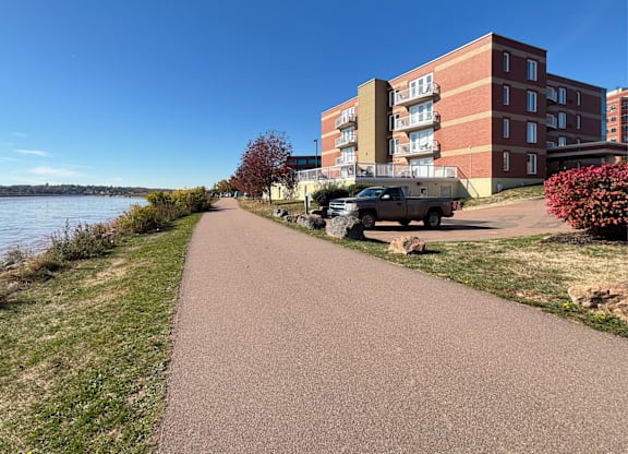 A pathway leads to a large brick building with a truck parked in front.