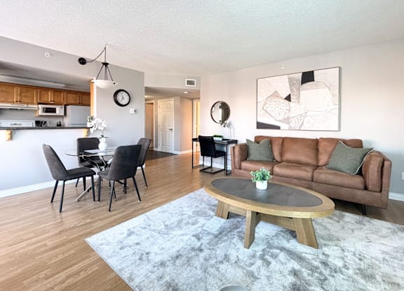 A modern living room with a grey rug and a brown couch.