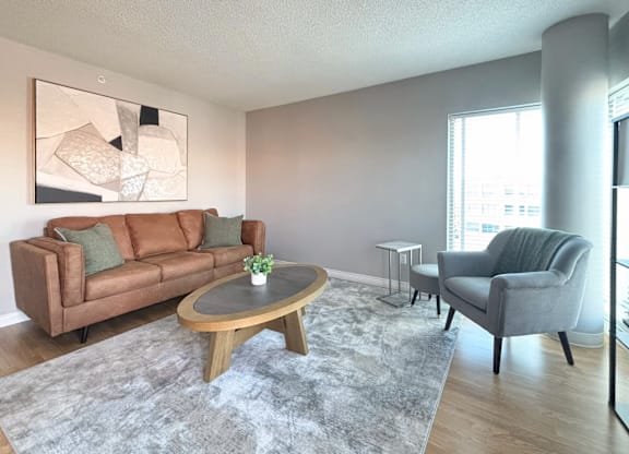 A living room with a brown couch, grey armchair, and a coffee table.