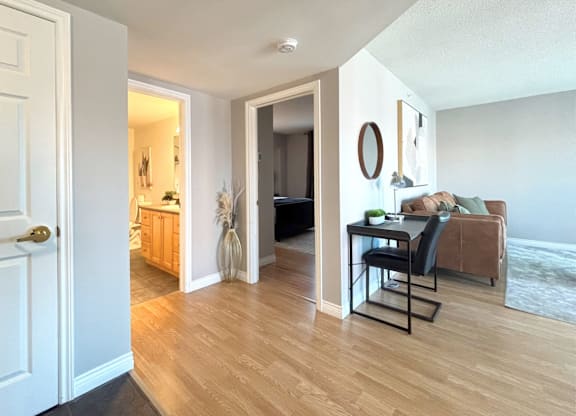 A modern living room with a brown couch and a black chair.