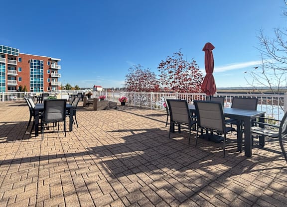A patio with a table and chairs overlooking a body of water.