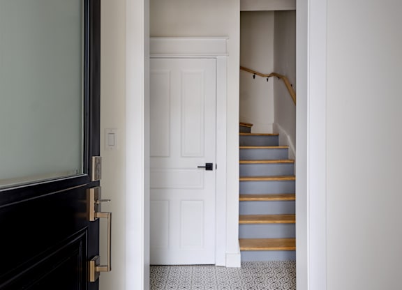 A white door is open to a staircase.