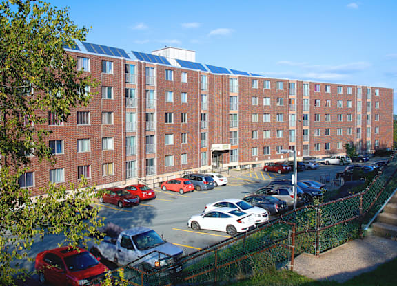 A parking lot in front of a red brick building.