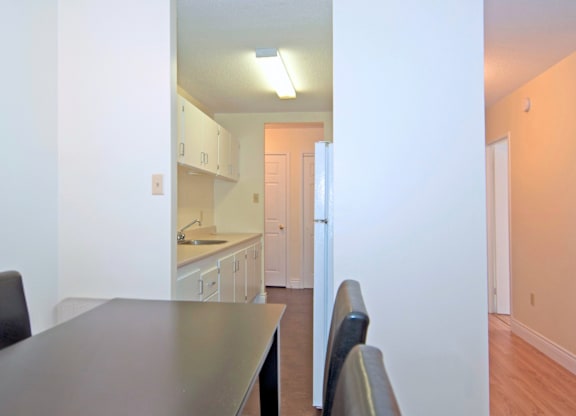 A kitchen with a table and chairs in the foreground.