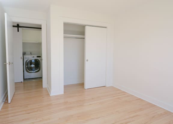 A white room with a washing machine in the doorway.
