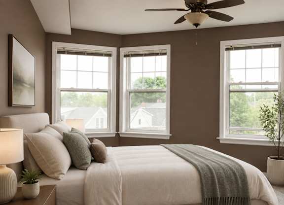 A bedroom with a large bed and a ceiling fan.