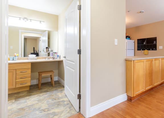 A kitchen with a white door open to a living room.