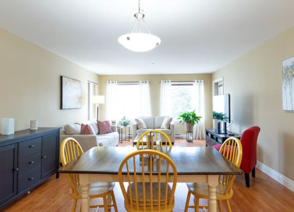 A dining room with a wooden table and chairs.