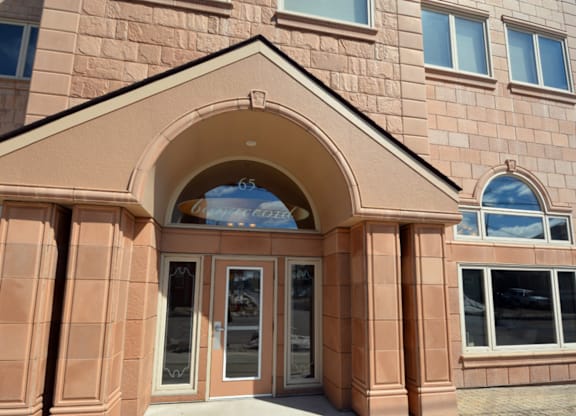 A building with a brown facade and a large arched entrance.