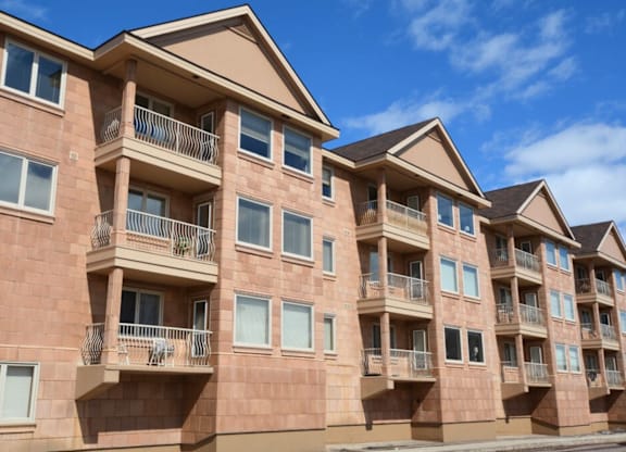 A row of apartment buildings with balconies and windows.