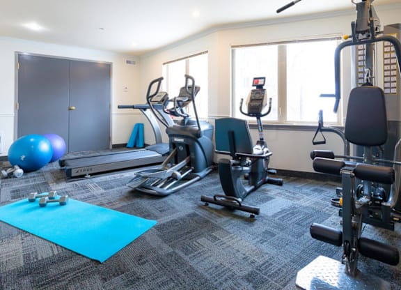 A gym with a variety of equipment including treadmills, exercise bikes, and weight machines.
