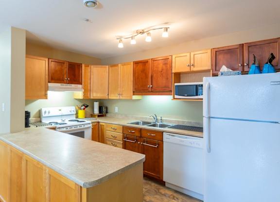 A kitchen with wooden cabinets and a white refrigerator.