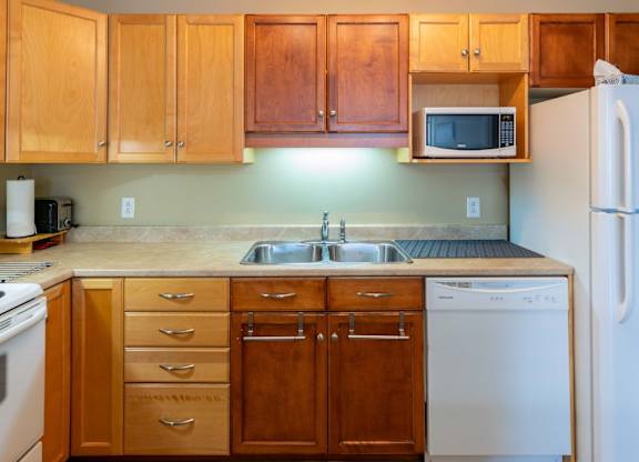 A kitchen with wooden cabinets and white appliances.
