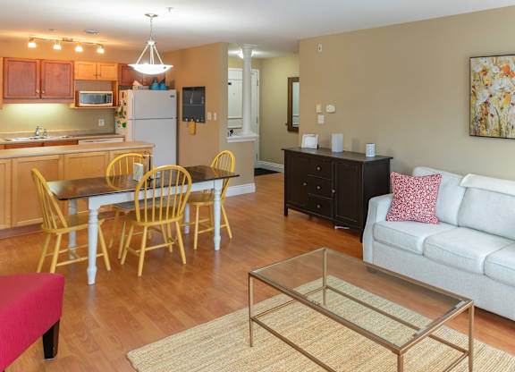 A kitchen with a dining table and chairs.