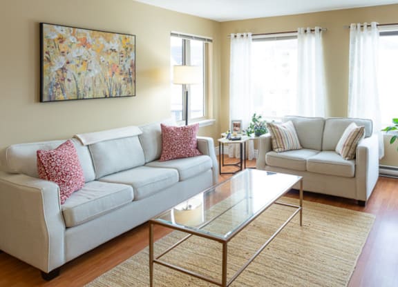 A living room with a large painting on the wall and two couches.