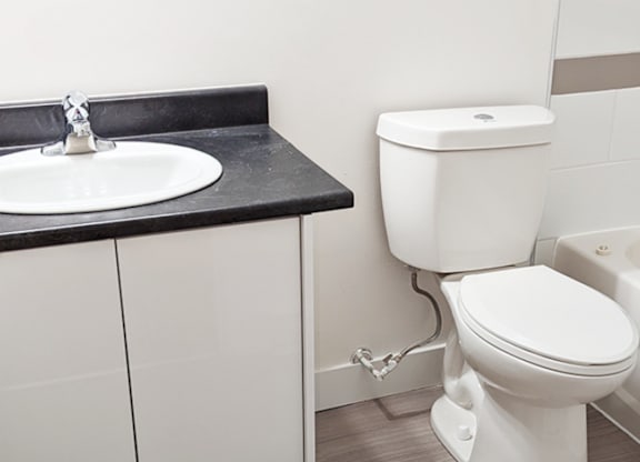 A white toilet is next to a sink in a bathroom.