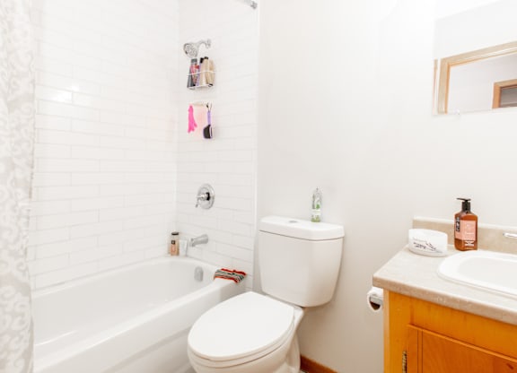 A white toilet sits next to a bathtub in a bathroom.
