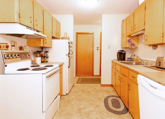 A kitchen with wooden cabinets and white appliances.