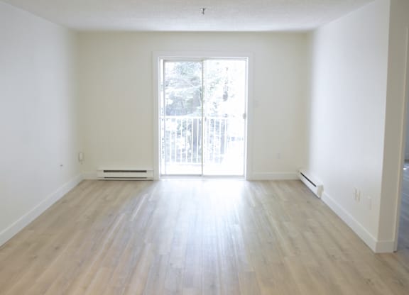 A room with a sliding glass door leading to a balcony.