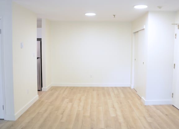 A room with wooden flooring and white walls.