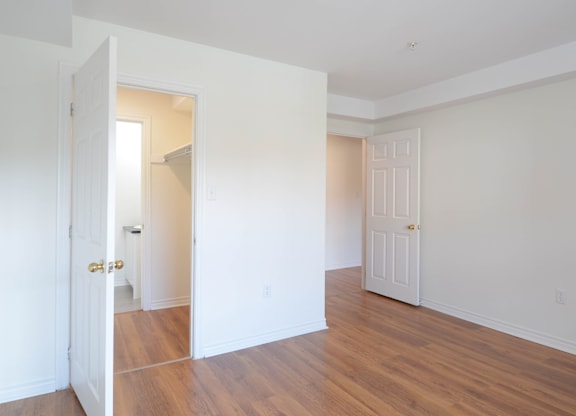 A room with a white door and a wooden floor.